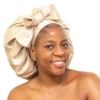 Woman wearing oversized champagne satin bonnet with soft structured luxury silhouette.