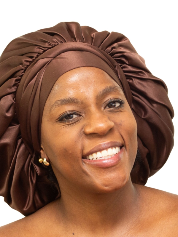 Woman wearing oversized chocolate brown satin bonnet designed for luxury overnight hair protection.