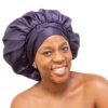 Woman wearing oversized navy satin bonnet for luxury natural hair protection.