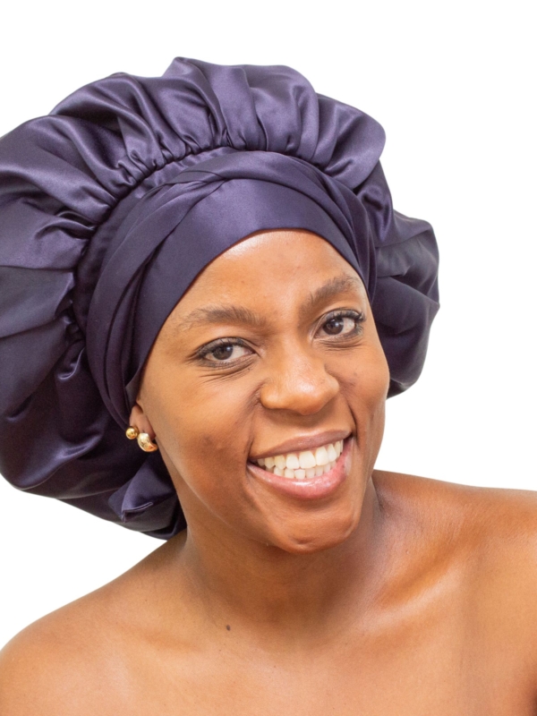 Woman wearing oversized navy satin bonnet for luxury natural hair protection.