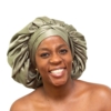 Woman wearing oversized deep olive satin bonnet designed for luxury natural hair protection.