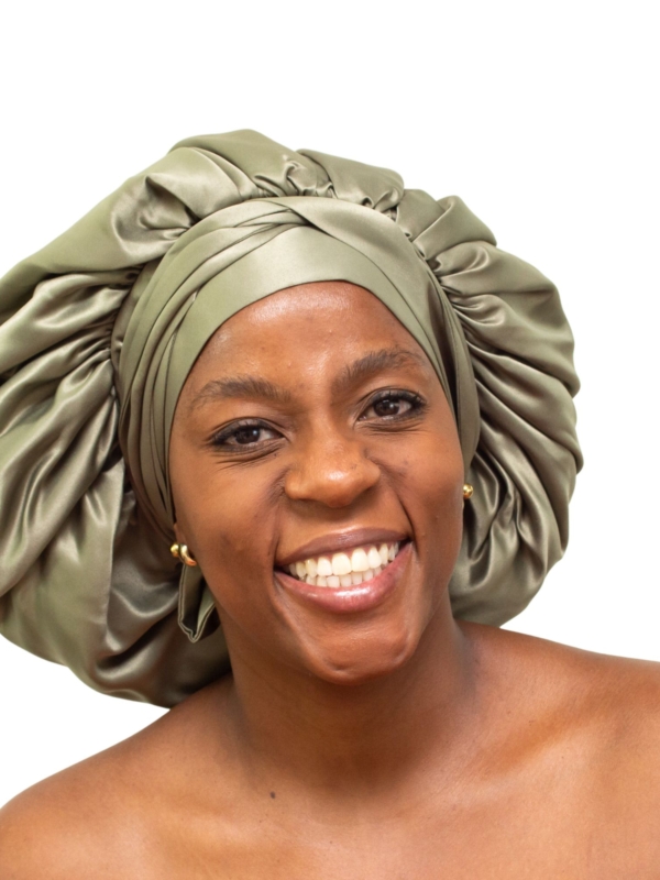 Woman wearing oversized deep olive satin bonnet designed for luxury natural hair protection.