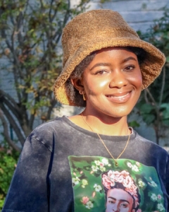 girl wearing tan brown bucket hat and graphic tshirt