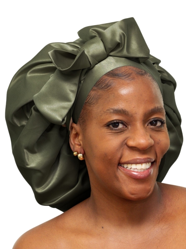 Woman wearing oversized deep olive satin bonnet designed for luxury overnight natural hair protection.