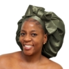 Woman wearing oversized deep olive satin bonnet designed for luxury overnight natural hair protection.